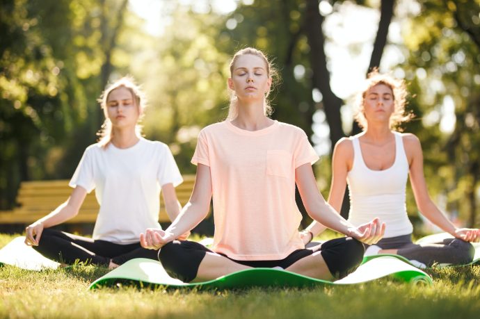 group-of-young-women-practicing-yoga-morning-meditation-in-nature-at-the-park.jpg